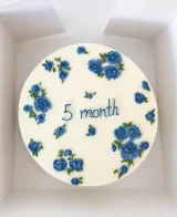 Bolo branco com rosas azuis e inscrição