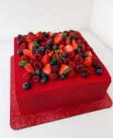 Torta quadrata rossa con fragole, lamponi e mirtilli