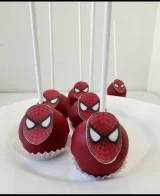 Cake pops roșii pe bețișoare albe, cu măștile Omului-Păianjen